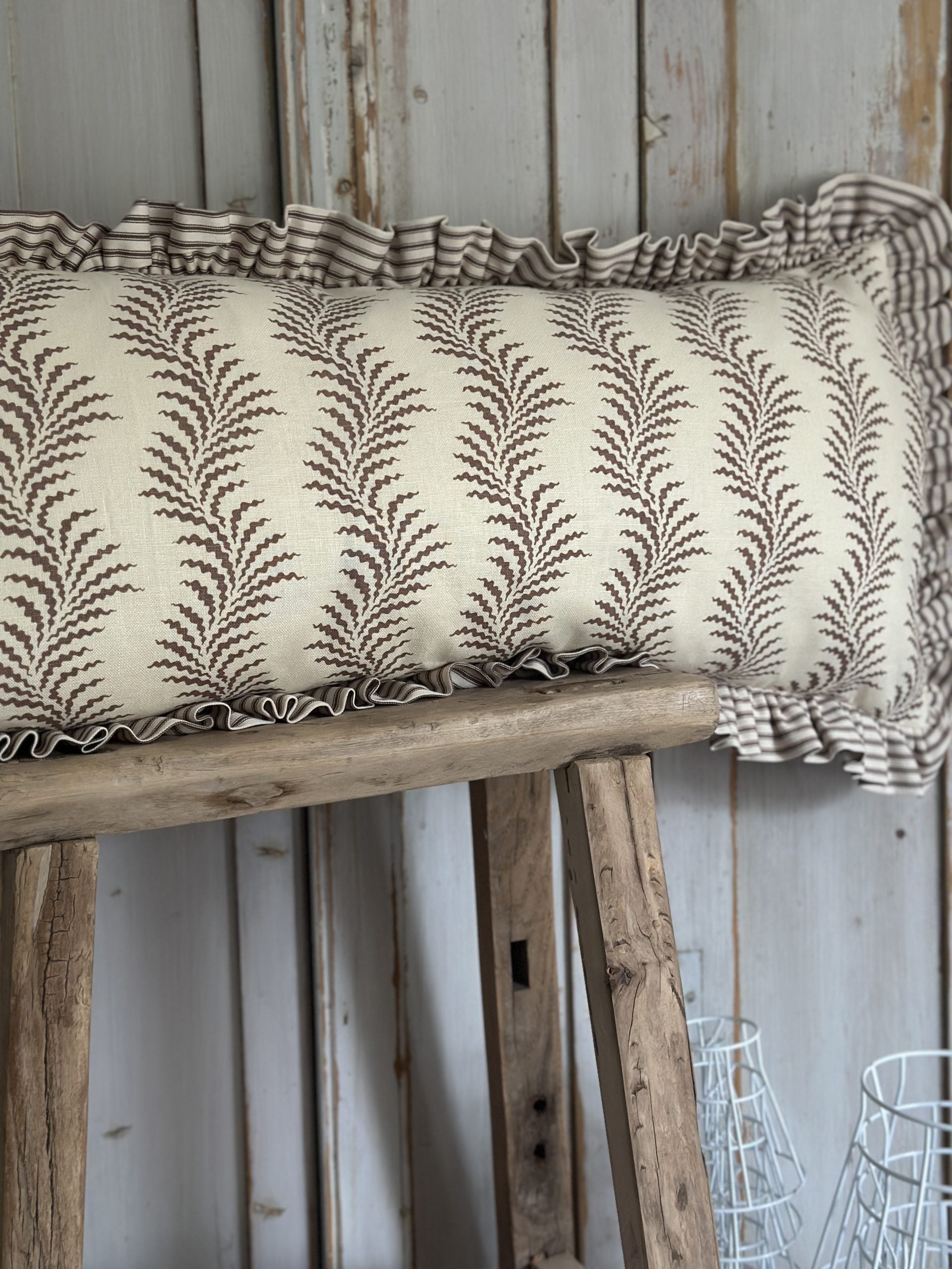 Scrolling fern and ticking stripe lumber cushion