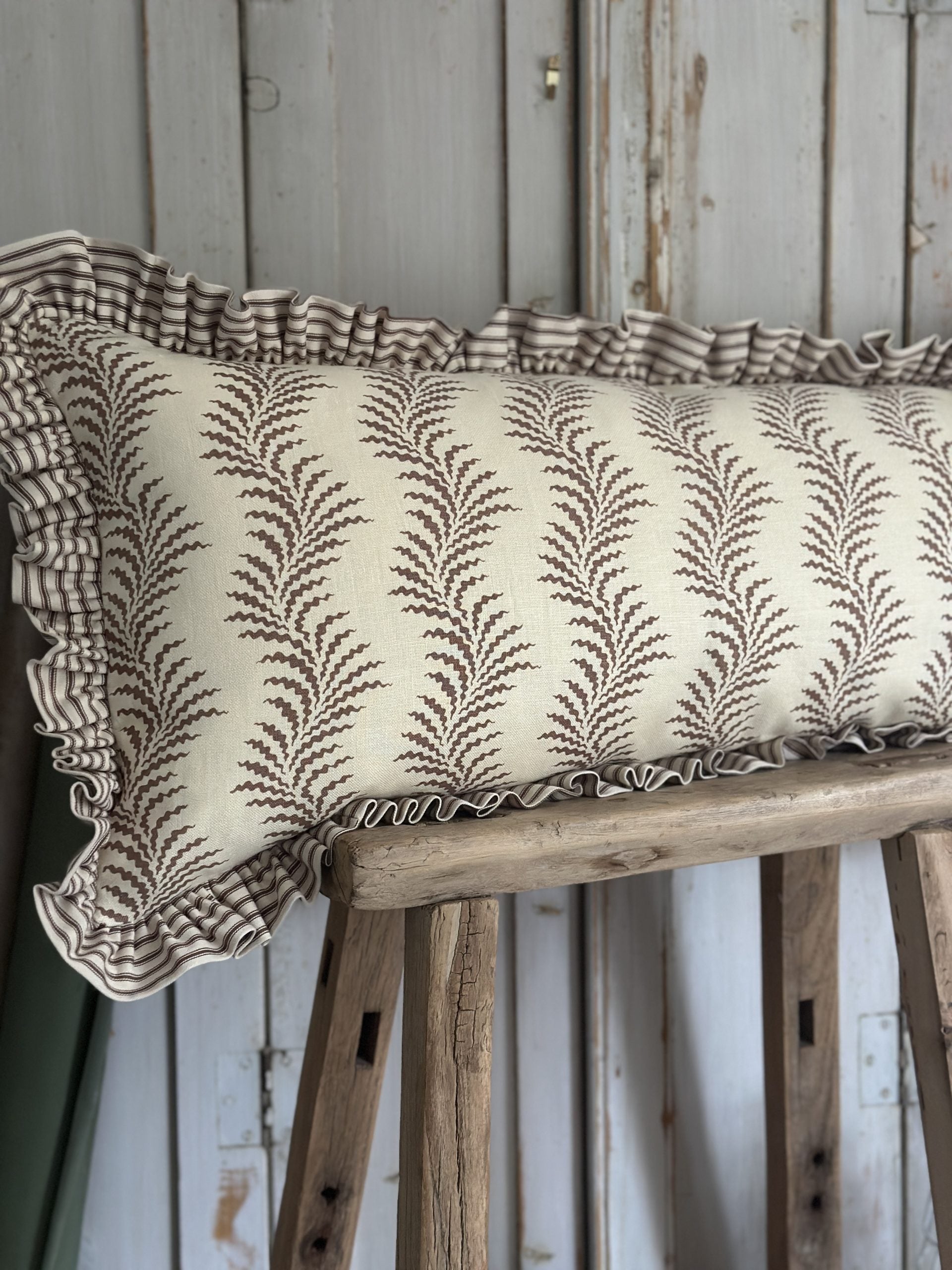 Scrolling fern and ticking stripe lumber cushion
