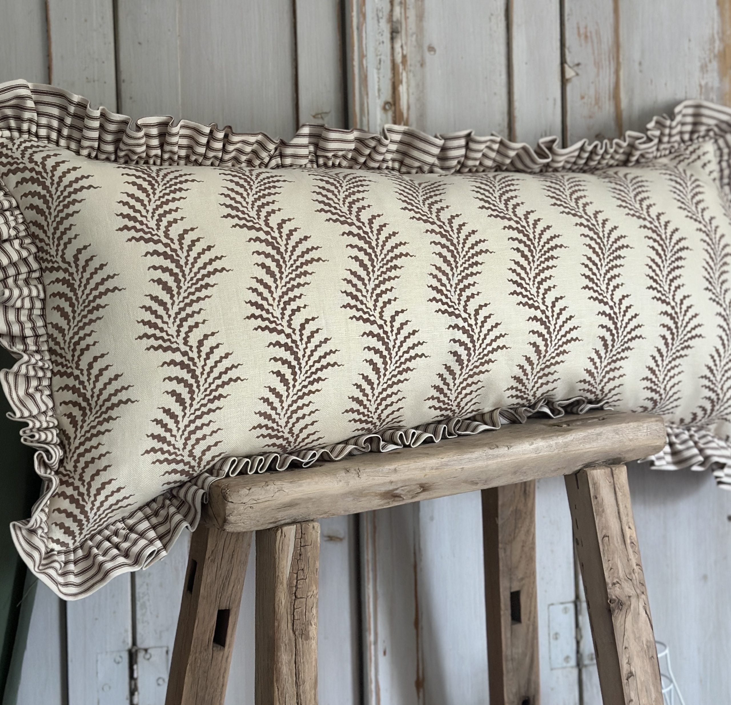 Scrolling fern and ticking stripe lumber cushion